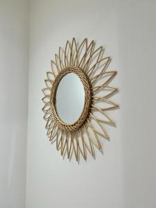 uno specchio dorato da sole appeso a un muro di Bienvenue chez Tom a Lamballe