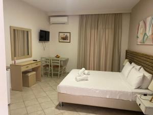 a hotel room with a bed and a desk and a mirror at Sivota Muses in Syvota