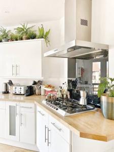 a kitchen with white cabinets and a stove top oven at Juniper House by Walpole Bay - Margate in Kent