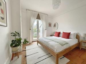 um quarto com uma cama com almofadas vermelhas e uma janela em Juniper House by Walpole Bay - Margate em Kent