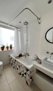 a bathroom with a tub and a toilet and a sink at Juniper House by Walpole Bay - Margate in Kent