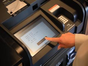 une personne pointant un doigt vers une machine à atm dans l'établissement Hotel Cocktail Stay Naha, à Naha