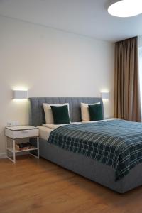 1 dormitorio con 1 cama con manta azul en Sonata apartment en Panevėžys