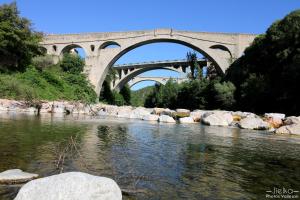 un puente sobre un río con un puente en el fondo en la cigogne, en Céret