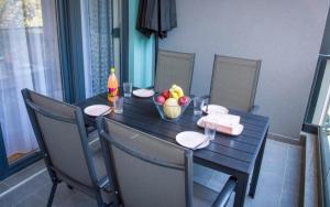 a table with a bowl of fruit and a bottle of juice at Apartman NOA EXCLUSIVE in Trebinje