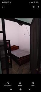 uma pequena cama num quarto com uma janela em Linda casa campestre em Agua de Dios