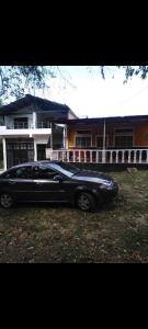 um carro preto estacionado em frente a uma casa em Linda casa campestre em Agua de Dios