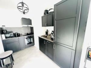 eine Küche mit grauen Schränken und einer Arbeitsplatte in der Unterkunft Bel Appartement avec Terrasse privée 86m2 in Noisy-le-Sec