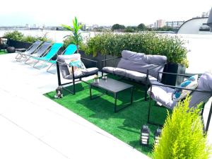 een patio met ligstoelen en een tafel op het dak bij Bel Appartement avec Terrasse privée 86m2 in Noisy-le-Sec