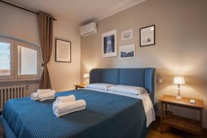 a bedroom with a blue bed with towels on it at Villa con Giardino Vista Mare in Castiglione della Pescaia