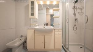a white bathroom with a sink and a shower at Villa con Giardino Vista Mare in Castiglione della Pescaia +54 photos