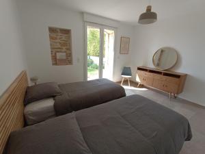 um quarto com 2 camas, um espelho e uma cómoda em Maison de Charme - Maréchalerie - Nîmes em Uchaud