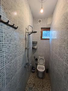 a bathroom with a toilet and a window in it at Karvi Hostel & Suites in Batumi