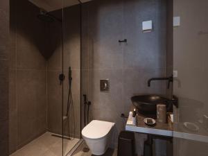 een badkamer met een douche, een toilet en een wastafel bij Grand Residences in Chania