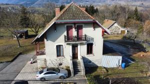 une maison avec une voiture garée devant elle dans l'établissement chambres d'hôtes des Bauges ROUTE 26 57, à La Motte-en-Beauges