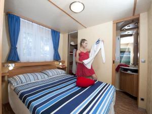 kobieta stoi obok łóżka w pokoju w obiekcie Detached chalet with AC, in a natural park on the coast w mieście Baia Domizia