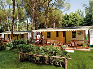 uma casa com pessoas sentadas fora dela em Detached chalet with AC, in a natural park on the coast em Baia Domizia