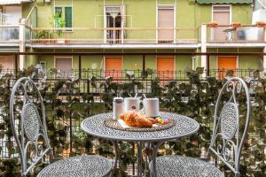 un tavolo con cornetto e tazze di caffè su un balcone di Divi Apartments - Strategic Place a Milano
