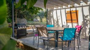 a table and chairs on a patio with a grill at Mon Ginesté in Flayosc