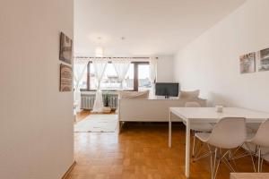 - un salon blanc avec une table et des chaises dans l'établissement Stilvolles Apartment für 4 Pers., à Brême