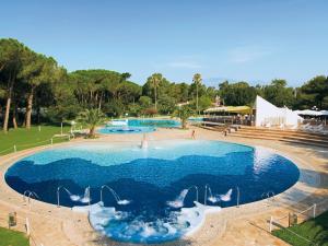 uma grande piscina com água azul num parque em Detached chalet with AC, in a natural park on the coast em Baia Domizia