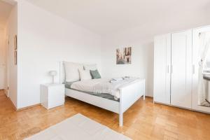 1 dormitorio blanco con 1 cama y armarios blancos en Stilvolles Apartment für 4 Pers., en Bremen