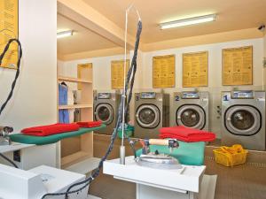 a laundry room with three washing machines and a sink at Detached chalet with AC, in a natural park on the coast in Baia Domizia