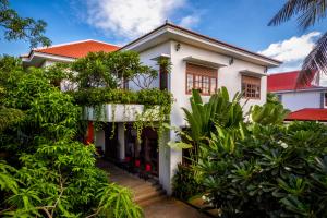 ein weißes Haus mit Pflanzen davor in der Unterkunft Sokkhak Boutique Resort & Spa in Siem Reap