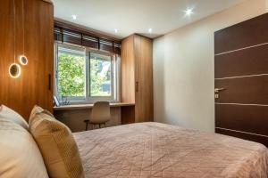 a bedroom with a bed and a window and a desk at B2 deluxe apartments in Alexandroupoli