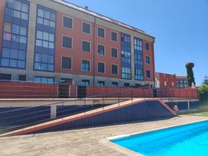 a building with a swimming pool in front of a building at Apartamento con piscina en Boiro - Cabo de Cruz in Boiro
