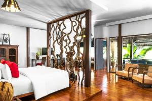 une chambre avec un grand lit blanc et un salon dans l'établissement Sokkhak Boutique Resort & Spa, à Siem Reap