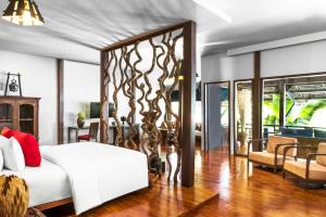 a bedroom with a large white bed and a living room at Sokkhak Boutique Resort & Spa in Siem Reap