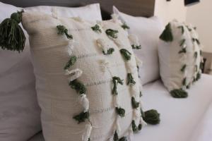 uma almofada branca com folhas verdes numa cama em House Štefanac em Seliste Dreznicko