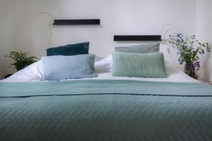 a bed with blue and green pillows on it at Lodge IJsvogel Nunspeet Veluwe in Nunspeet