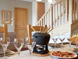 - une table avec des verres à vin et une assiette de nourriture dans l'établissement Modern apartment near the ski lift in an authentic village, à Sainte-Foy-Tarentaise