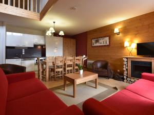 a living room with a red couch and a table at Modern apartment near the ski lift in an authentic village in Sainte-Foy-Tarentaise