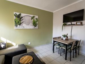 a living room with a couch and a table with chairs at Meerkat Manor Self-Catering & Accommodation Windhoek in Windhoek