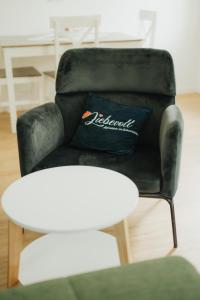 a black leather chair with a pillow on it at Liebevoll Gästewohnungen in Alpirsbach