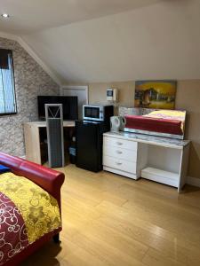 Habitación con cama y escritorio con microondas. en The Caduceus- Residence, en Chertsey