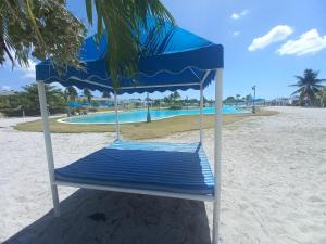 a blue and white chair on a beach with a pool at ADVENTURE House in Nancito