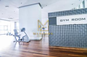 een kantoor met een fitnessruimte met een loopband en een fitnessruimte bij Maxhome@Regalia suite residence. KL in Kuala Lumpur