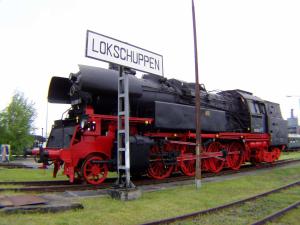 un treno rosso e nero fermo sui binari di zz_Lokschuppen Pasewalk-Erlebnisübernachtung im Schlafwagen a Pasewalk