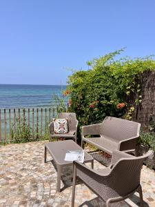 un patio con mesa, sillas y el océano en Residenza Fontanelle-Beach Resort en Santa Maria di Castellabate