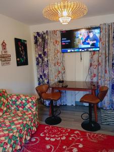 San Pablo laguna staycation في سان بابلو: غرفة معيشة مع مكتب وتلفزيون على الحائط