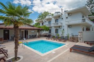 eine Villa mit Swimmingpool vor einem Haus in der Unterkunft SEKRETO hotel in Parga