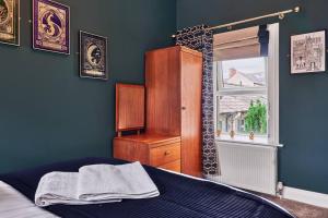 a blue bedroom with a bed and a window at The Snug @ Clarence in Derry Londonderry