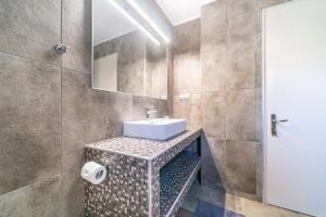 a bathroom with a sink and a mirror at Giourgas house in Chlomatianá +24 photos