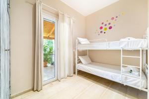 a room with two bunk beds and a window at Giourgas house in Chlomatianá