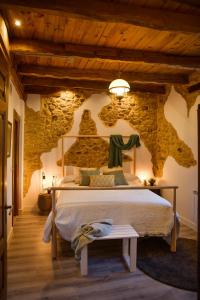 a bedroom with a bed and a stone wall at Casa ENTREPIEDRAS in Villalís
