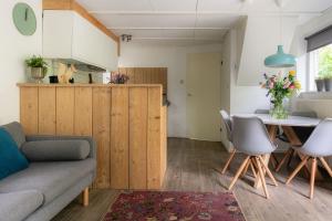 een woonkamer met een bank en een tafel bij Vakantiehuis Veluwe Bosuil Nunspeet in Nunspeet